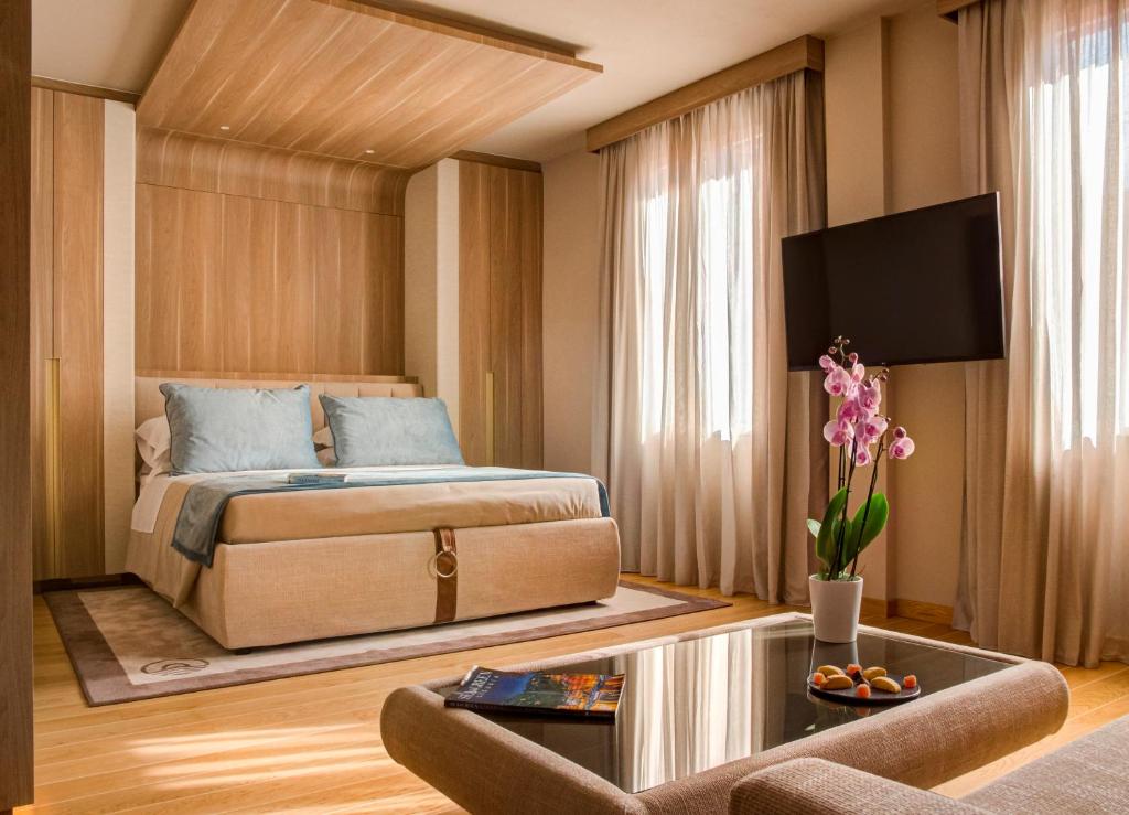 东塞斯特里Miramare Suites的一间卧室配有一张床、一张沙发和一张桌子