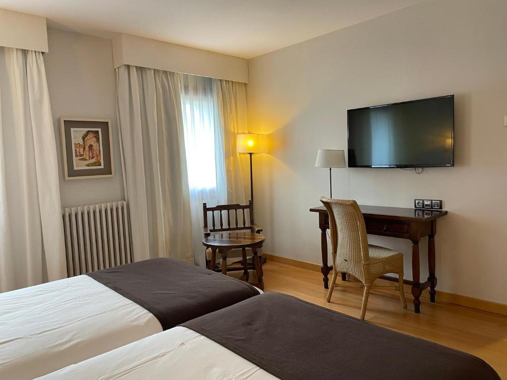普韦布拉桑纳比亚普韦布拉德萨纳夫里亚旅馆的酒店客房配有一张床、一张书桌和一台电视。