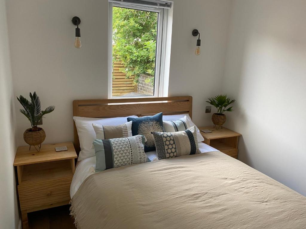 伊斯特布恩Old Town Oasis的卧室配有带枕头的床铺和窗户。