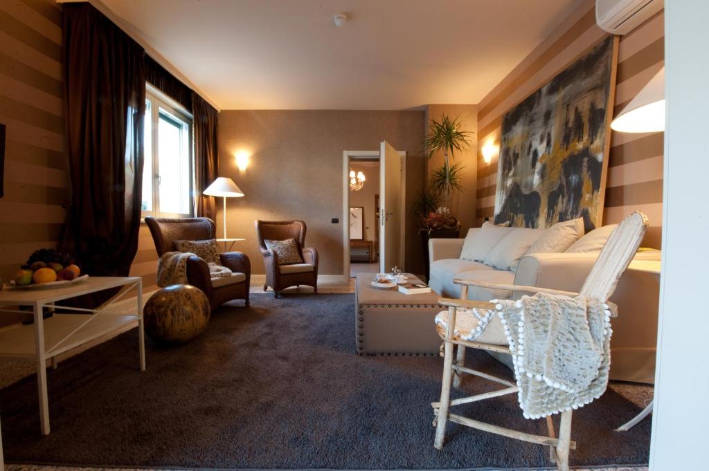 科洛尔诺洛坎达斯汤达酒店的客厅配有白色的沙发和椅子