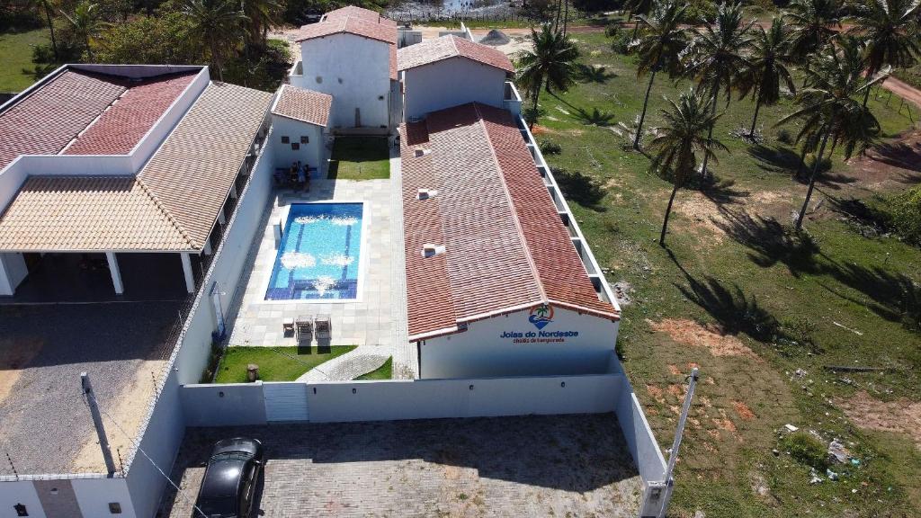 托鲁斯Joias do Nordeste - Chalés para Temporada的享有带游泳池的房屋的空中景致