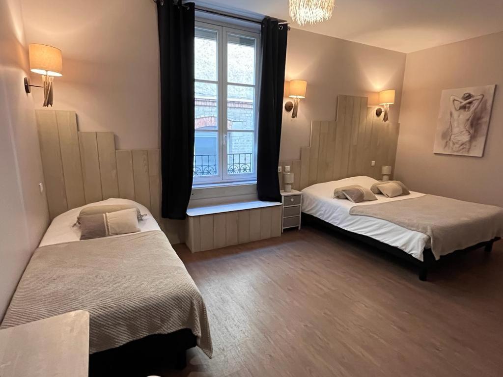 香槟沙隆波特戴塔尹酒店的带窗户的客房内的两张床