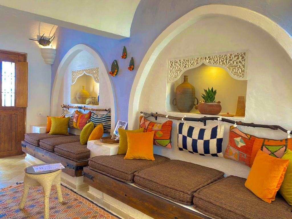 米多恩Hôtel Djerba Authentique - Au centre de Midoun的一个带拱门的房间,客厅里设有两张沙发