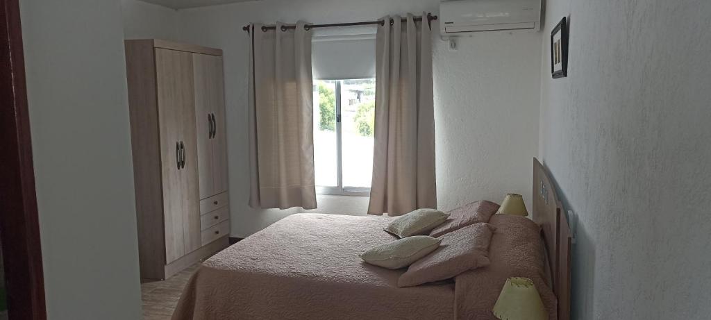 米纳斯Hosteling Las Margaritas的卧室配有带枕头的床铺和窗户。