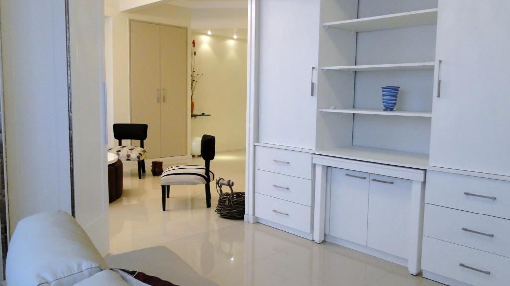 布宜诺斯艾利斯Recoleta Luxury Apartment的客厅配有白色橱柜和椅子