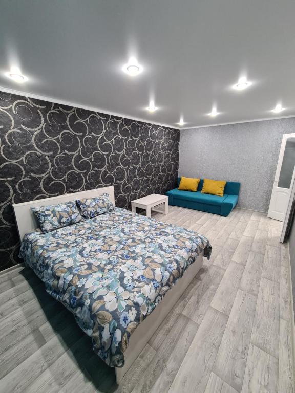 彼得罗巴甫洛夫斯克Однокомнатная квартира в центре Петропавловска的一间卧室配有一张床和一张蓝色的沙发