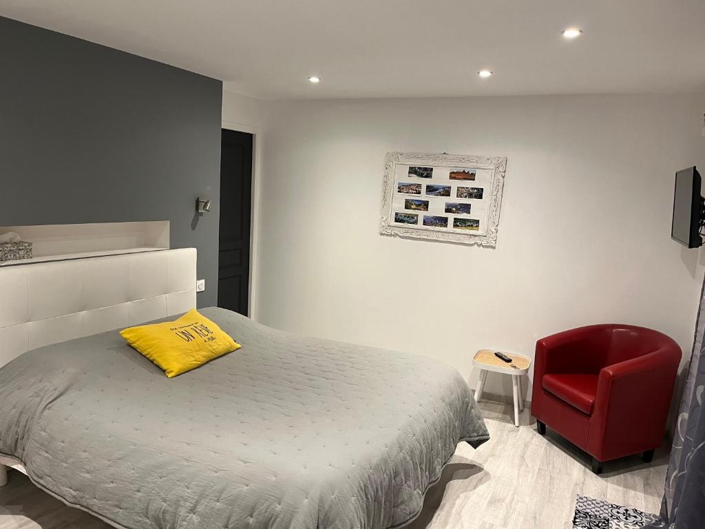 米洛Loubat Christophe的一间卧室配有一张床和一张红色椅子
