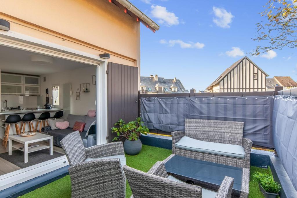 卡布尔Charming duplex with big terrace- Cabourg - Welkeys的一个带椅子和桌子的小阳台