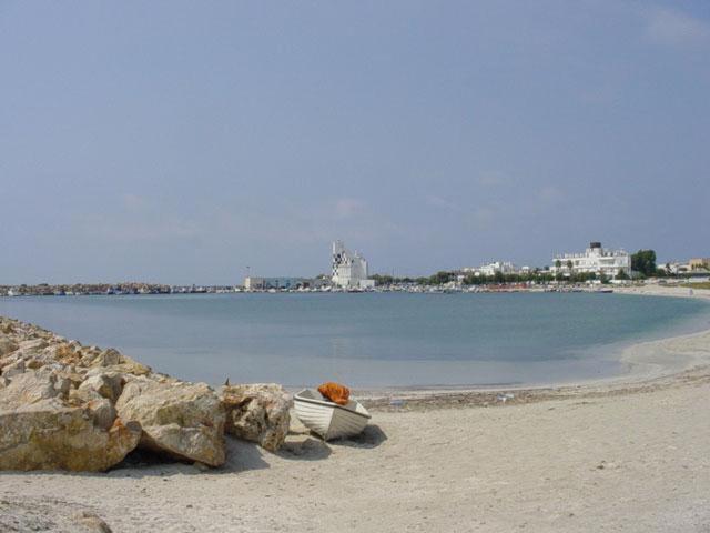 拉卡莱Casa Vacanza Aurora 6-8 posti letto的坐在岩石旁的海滩上的船