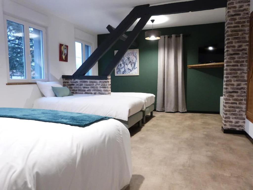 ArdresAux Portes des Lacs的一间卧室设有两张床,拥有绿色的墙壁