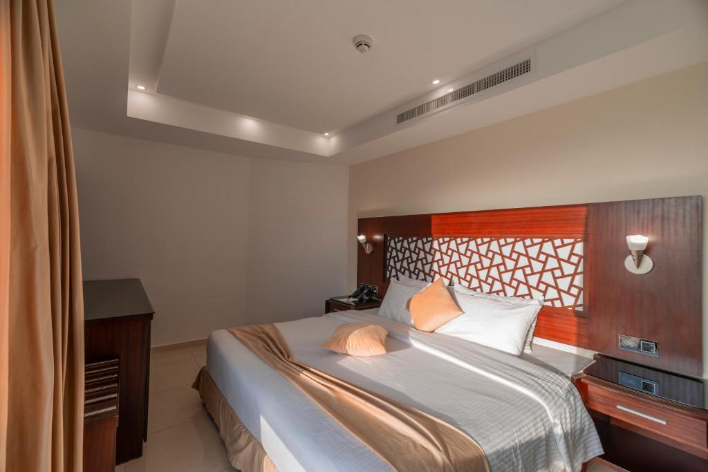 瓦迪穆萨Petra Elite Hotel的一间卧室配有一张大床和木制床头板