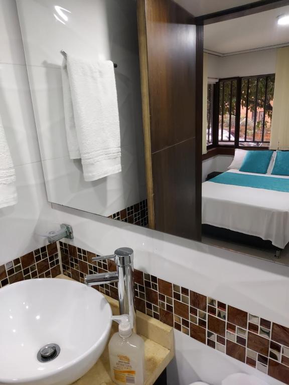 麦德林Apartaestudio Laureles - Viva Laureles的一间带水槽和镜子的浴室以及一张床