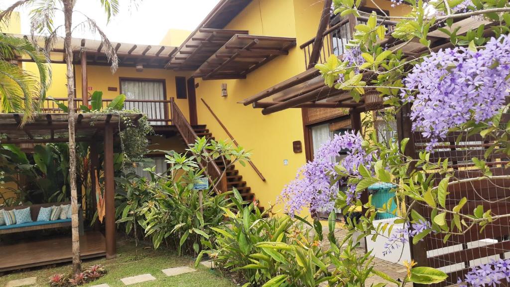 伊塔卡雷Conchas do Mar Residence的紫色花房前的花园