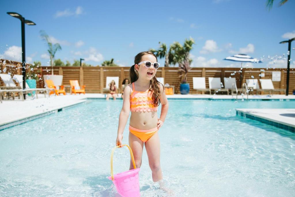 格尔夫海岸Hotel Indigo Orange Beach - Gulf Shores, an IHG Hotel的站在游泳池里的比基尼的小女孩