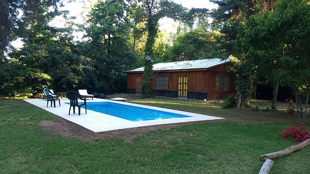 卢汉德库约Entrepinos Mendoza的庭院内一个带桌椅的游泳池