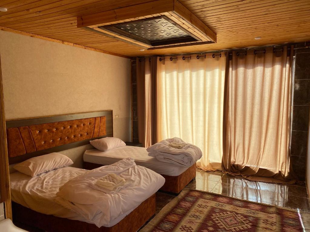 瓦迪拉姆Desert Jewel Camp的带窗户的客房内设有两张单人床。