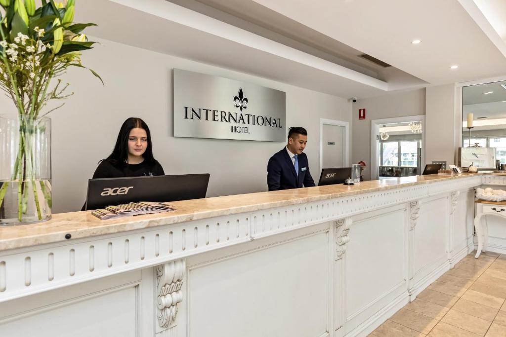 沃加沃加沃加沃加国际酒店的两人站在信息台的接待台