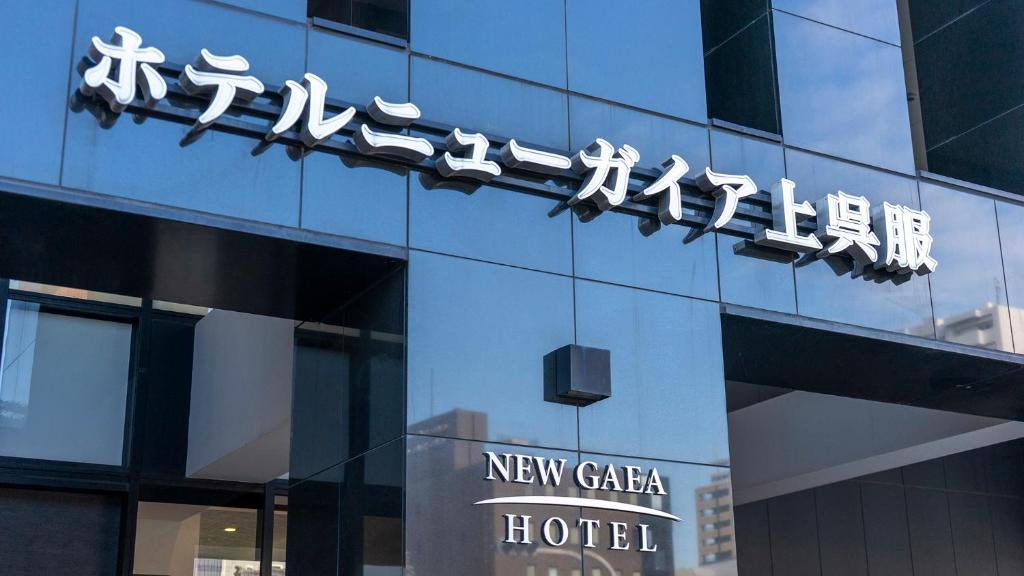 福冈Hotel New Gaea Kamigofuku的大楼一侧的新时代酒店标志