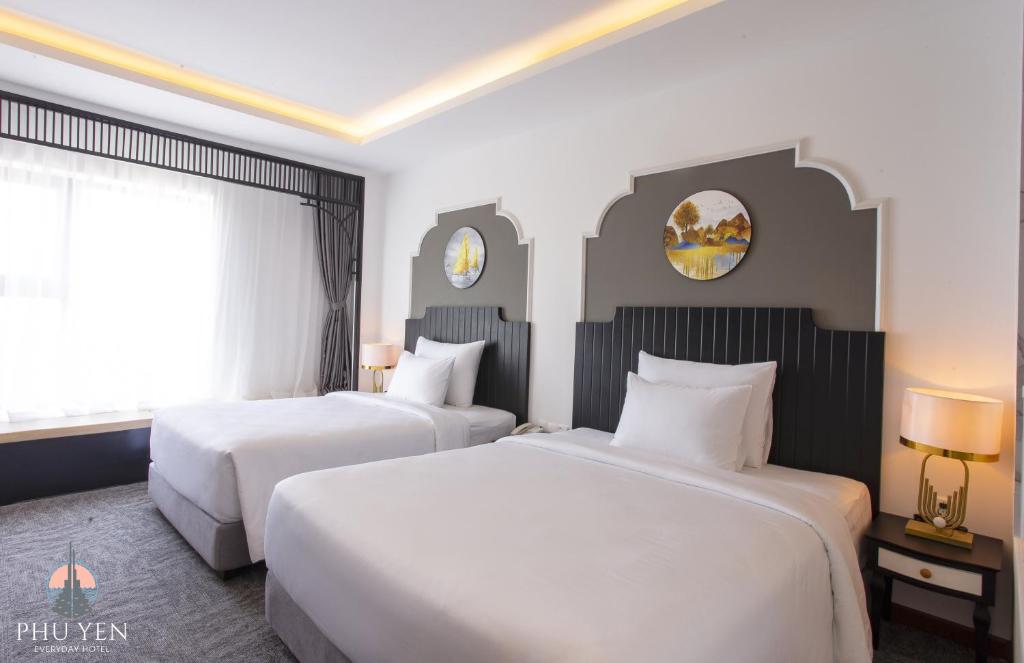 绥和市PHÚ YÊN EVERYDAY HOTEL的酒店客房设有两张床和窗户。