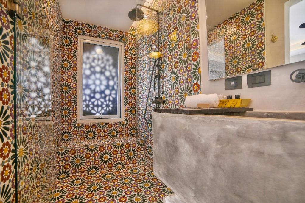 图卢姆Layla Tulum - Adults Only的浴室设有淋浴,墙上铺有彩色瓷砖。