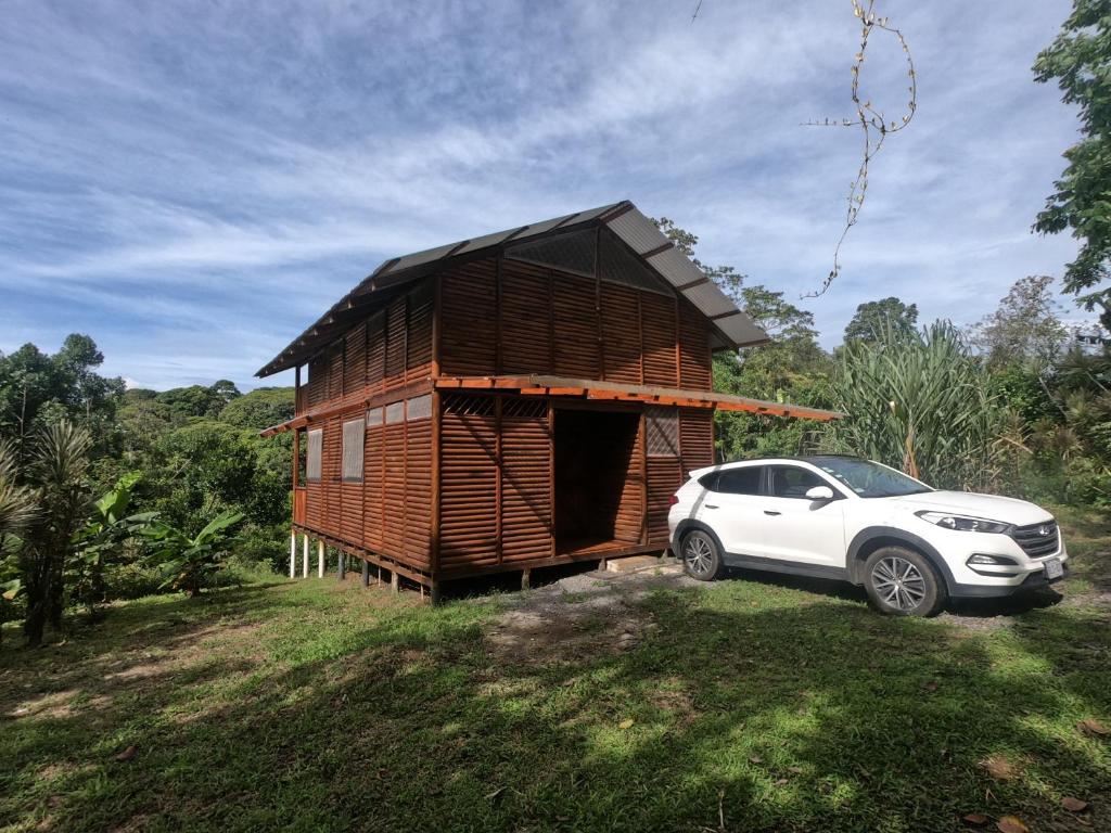 萨拉皮基Eco Guest House - Sarapiquí 1的一座小型木屋,旁边设有停车场