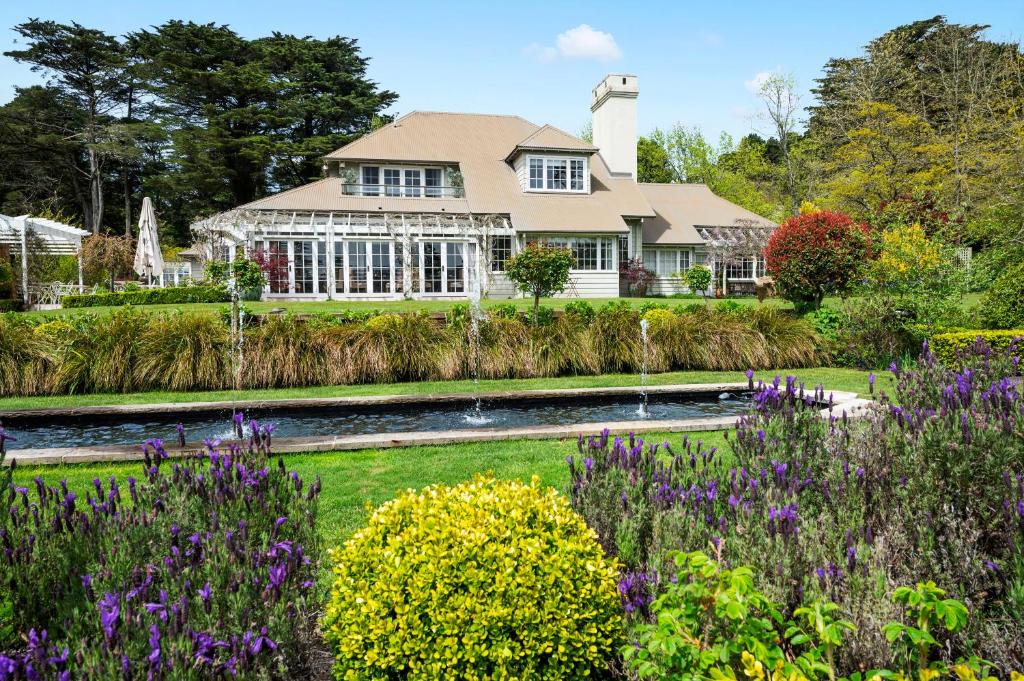黑荒地Parklands Country Gardens & Lodges Blue Mountains的前院中带花园的房屋