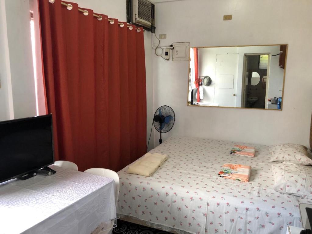 马尼拉THE MANSION - 2 PAX SOLO BUDGET Room near AIRPORT TERMINAL的一间小卧室,配有一张床和镜子