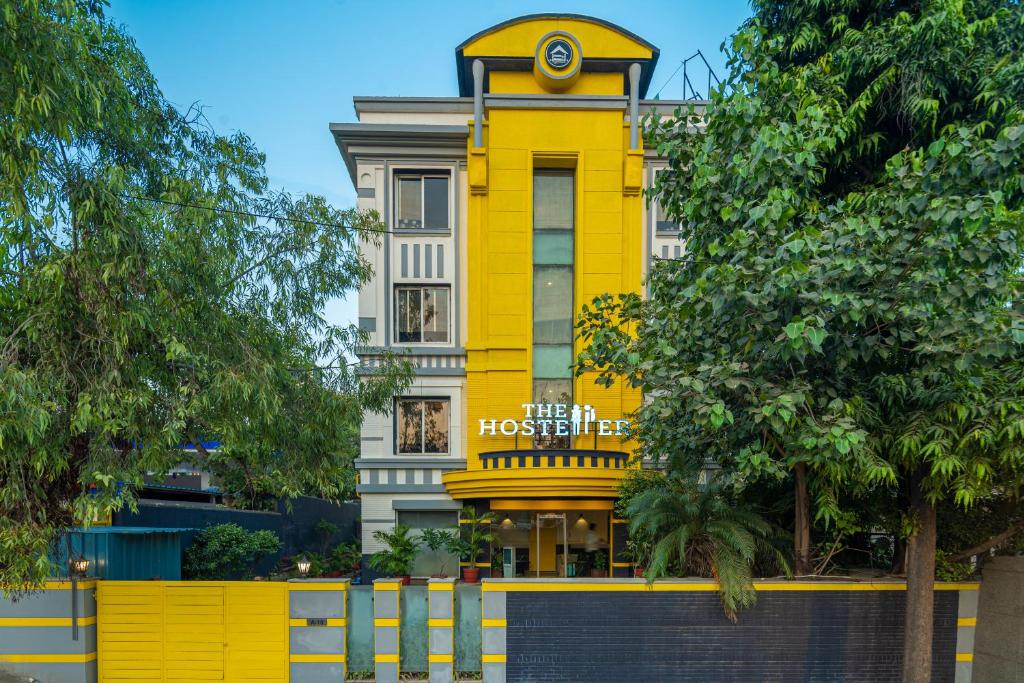 新德里The Hosteller Delhi的黄色的建筑,上面有钟