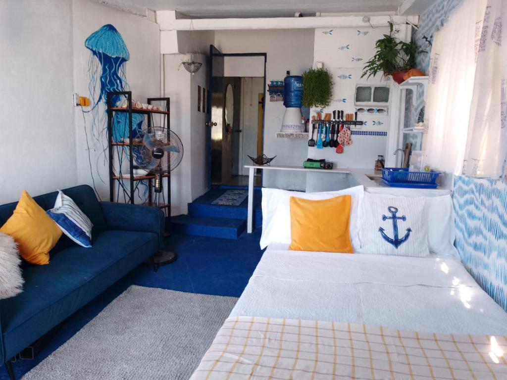 DaanbantayanLittle Sanity Beach house的客厅配有蓝色的沙发和黄色的枕头。