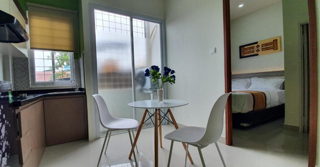 TanjungredepREG GUESTHOUSE的一张小桌子和椅子,位于一个配有床的房间