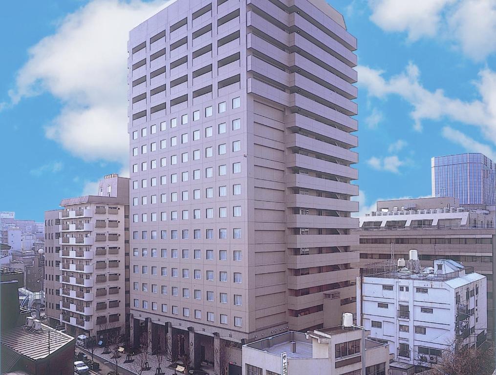 东京MYSTAYS 大森精品酒店的一座高大的白色建筑,有建筑