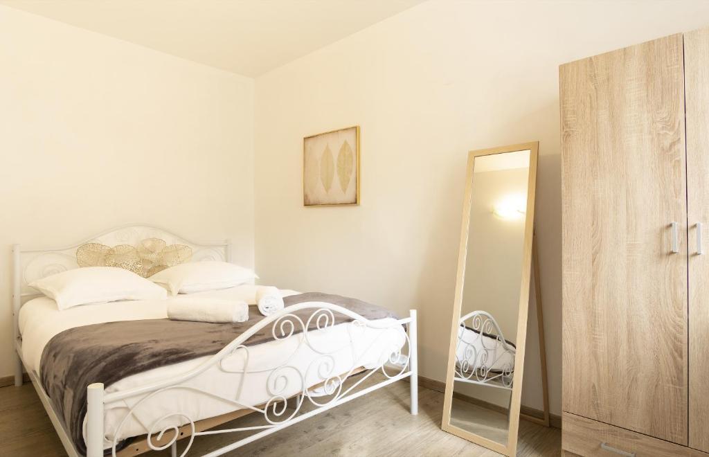 安锡Joli T2 industrie hyper centre Annecy的白色卧室配有床和镜子