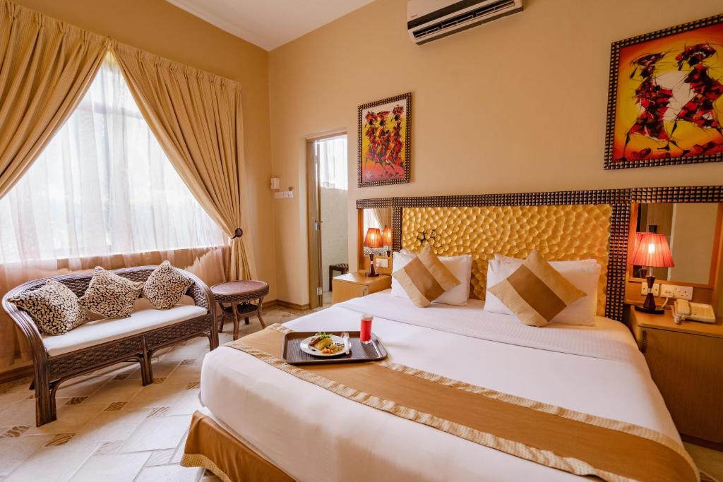 达累斯萨拉姆The Amariah Hotel & Apartments Mikocheni的酒店客房设有一张大床和一张沙发。