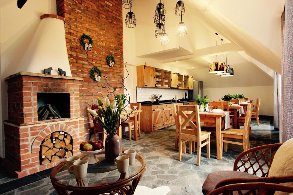 拉布卡KOŃSKA GÓRKA Agroturystyka的厨房以及带砖砌壁炉的用餐室。