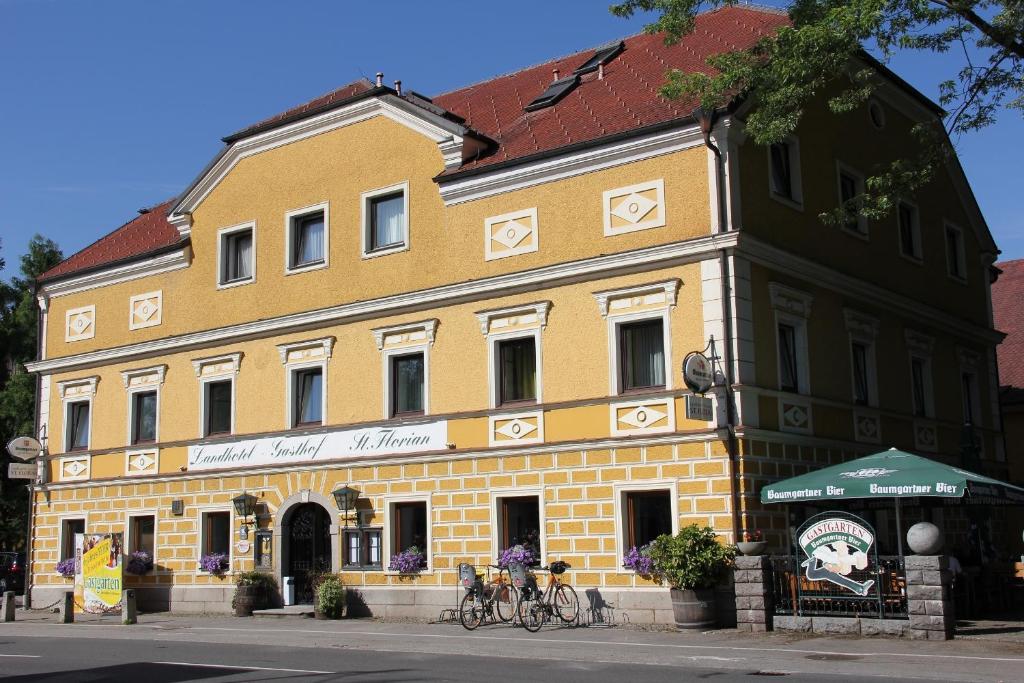 桑卡特弗洛里阿姆因圣弗洛里安酒店的一座黄色的建筑,前面有两辆自行车停放