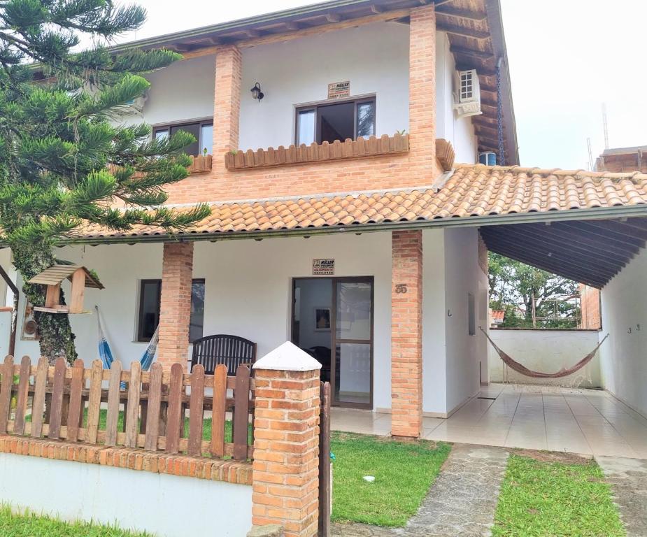 伊塔波阿Casa Conforto! A sua casa de praia em Itapoá - SC的前面有围栏的房子