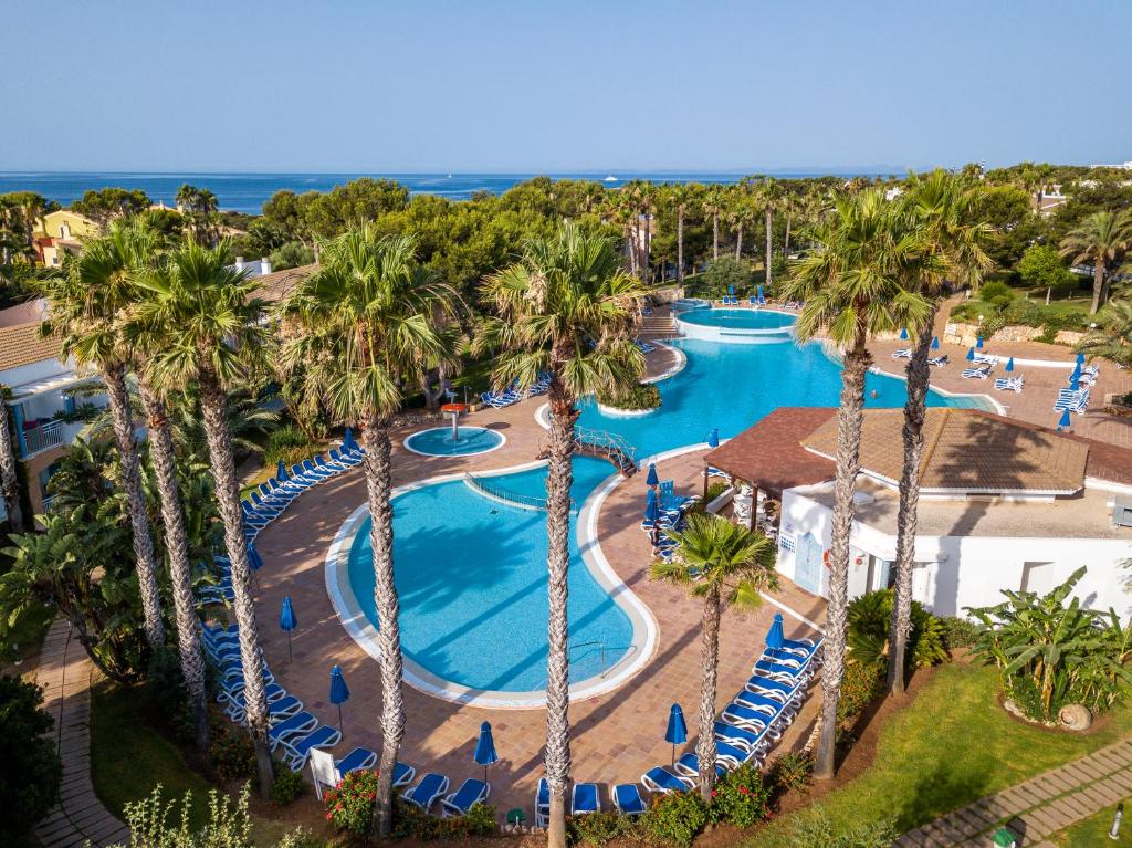 松霍里吉尔Sagitario Princesa Playa的享有棕榈树度假村泳池的顶部景致