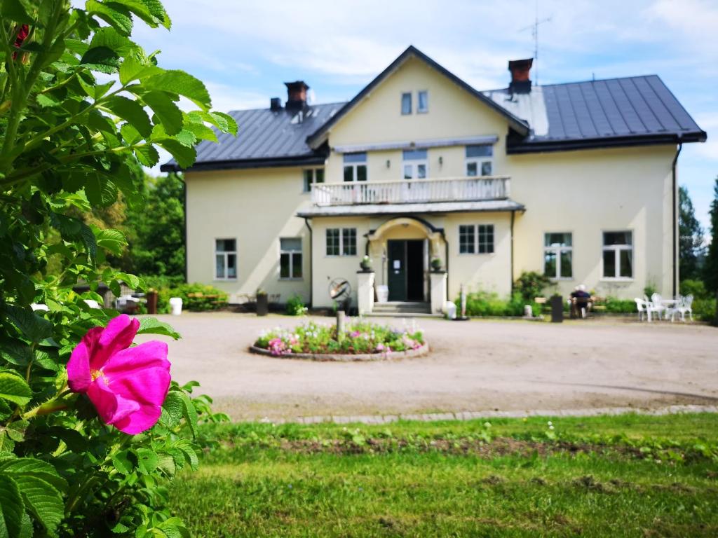 GrängesbergDisponentparken Café och Bed & Breakfast的前面有粉红色花的房子