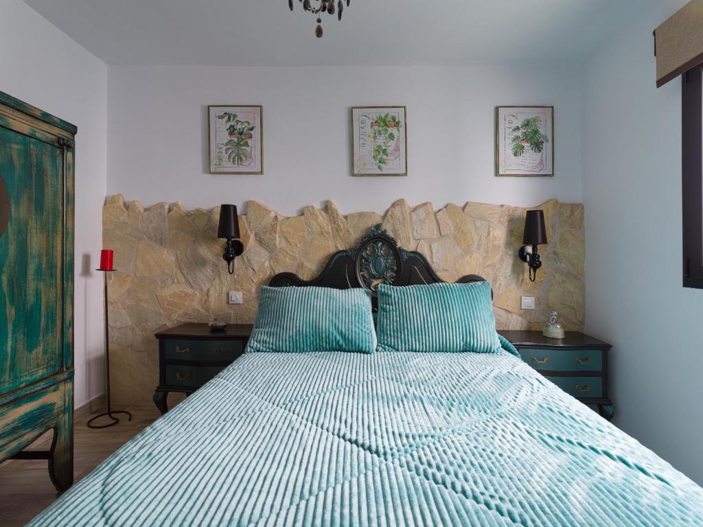 贝加德圣马特奥Viviendas vacacionales San Mateo的一间卧室配有一张带蓝色枕头的大床