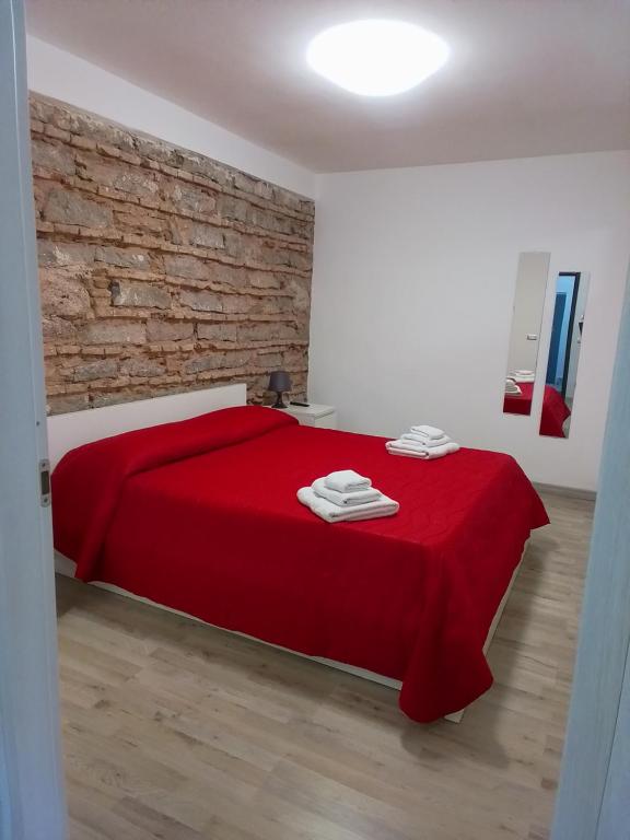卡塔尼亚Loft Home Sweet Home的一间卧室配有一张红床和砖墙