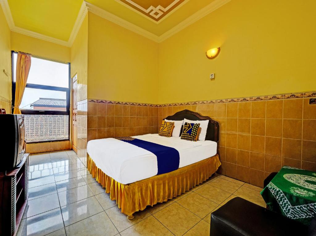 三宝垄SPOT ON 91912 Hotel Citra Dewi 2的一间卧室设有一张床和一个大窗户