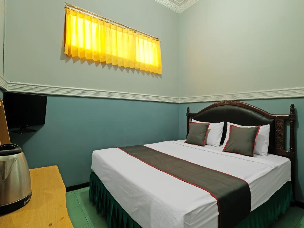 三宝垄Collection O 91914 Hotel Citra Dewi 2 Int's的一间卧室设有一张大床和窗户