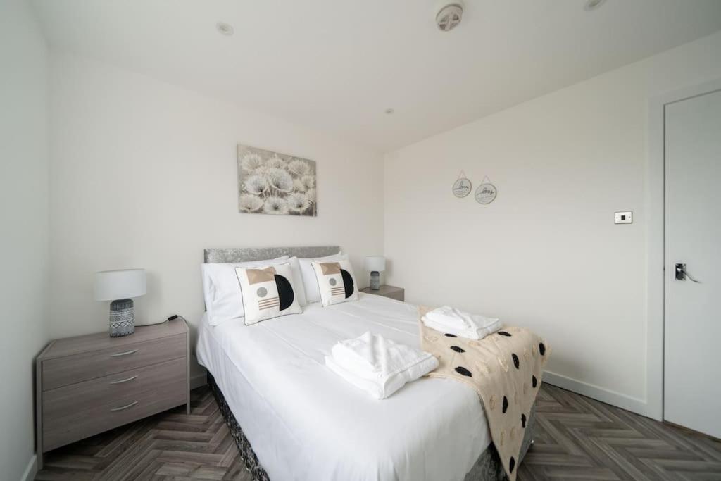 阿伯丁Links Loft -2 bed apartment minutes from Aberdeen beach的一间白色卧室,配有床和床头柜