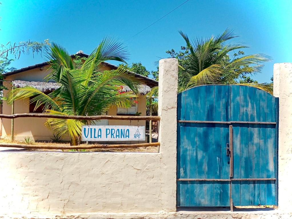 巴拉格兰德Vila Prana的棕榈树建筑前的蓝色门