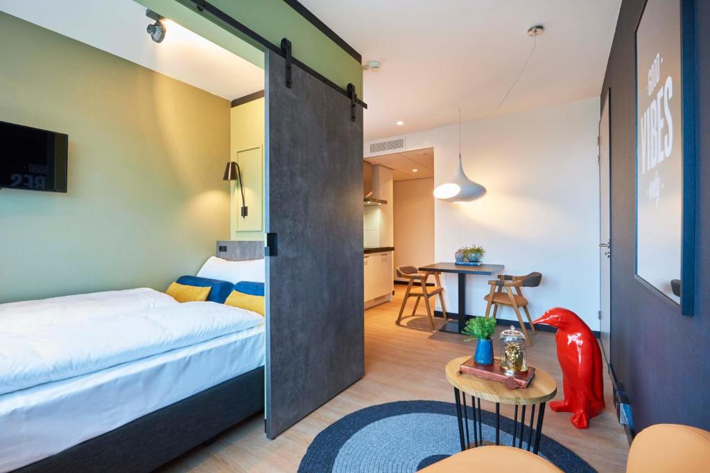 阿姆斯特尔芬Cityden Zuidas的一间卧室配有一张床和一张桌子及一张桌子