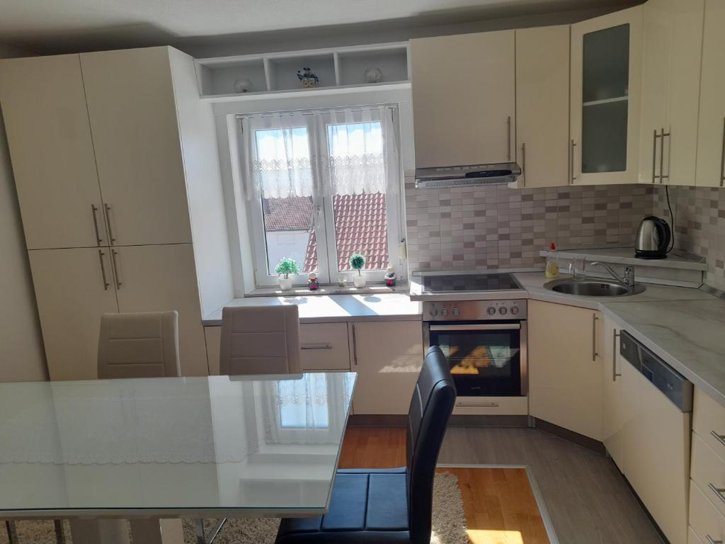 利夫诺Apartman Zoran的厨房配有白色橱柜和炉灶烤箱。
