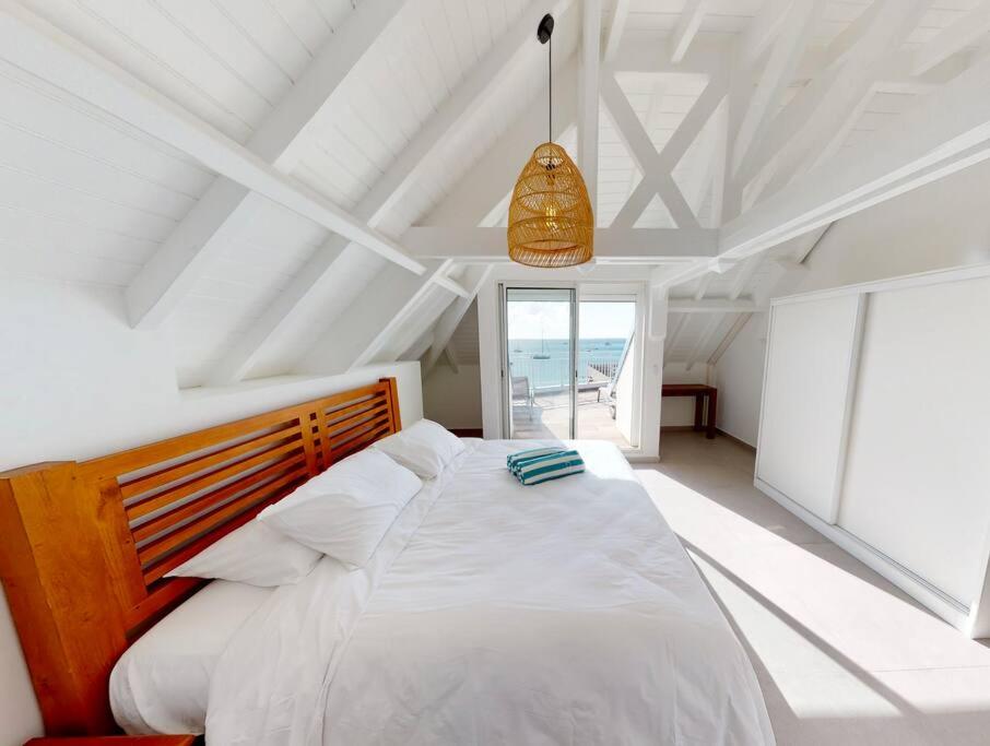 圣马丁岛Walee Beach Penthouse by the sea, 2 bedrooms, pool的卧室设有一张白色大床和一扇窗户。