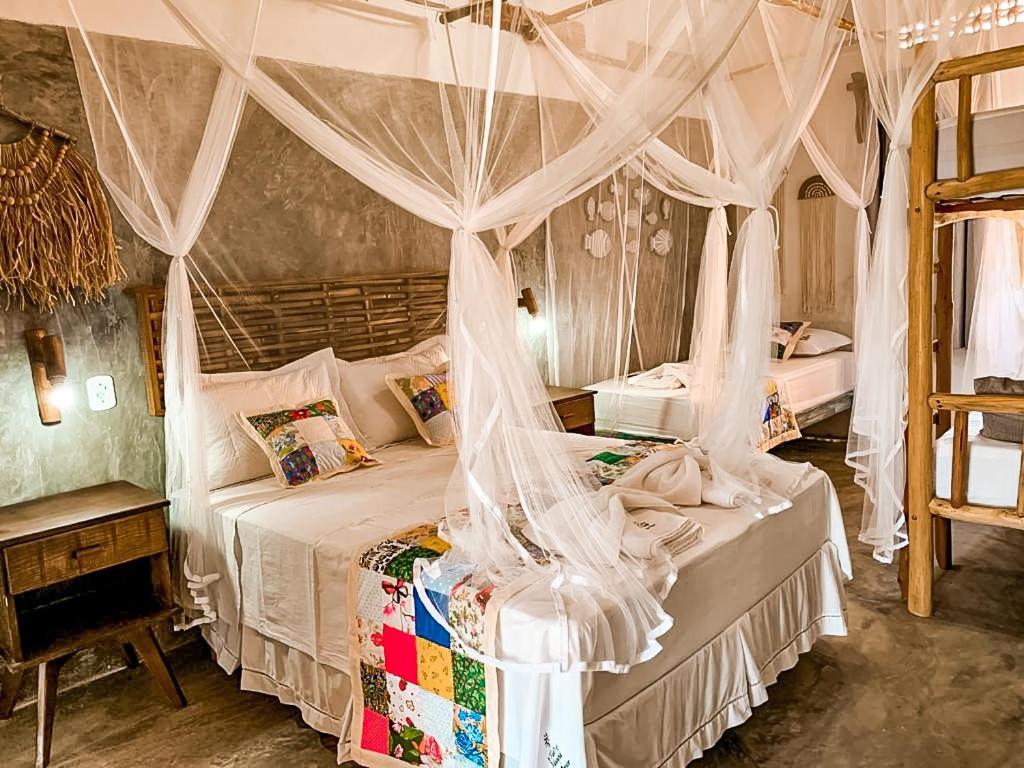 路易斯科雷亚FLATS MACAPÁ MEU AMOR 7的一间卧室配有带蚊帐的天蓬床。