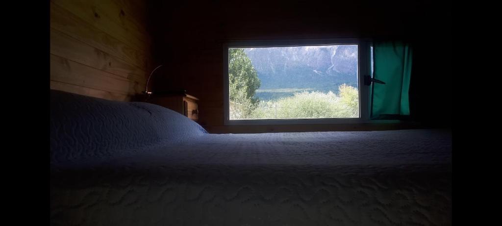 埃博森Sur tiny house的一间卧室设有一张床和一个窗口