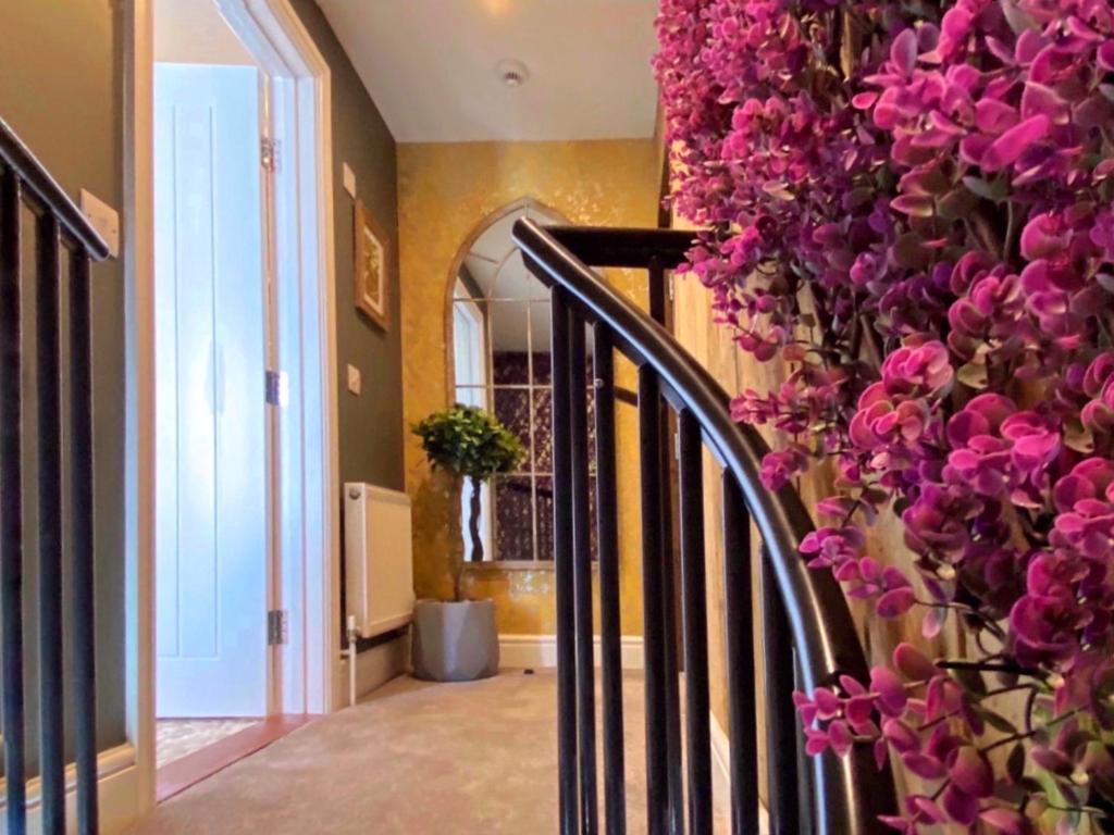 坎特伯雷Luxury tree-house with optional ESPA Spa的走廊上设有粉红色花卉楼梯